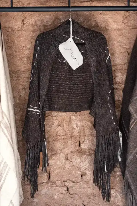 Ruana marrón con diseños lineales y flecos